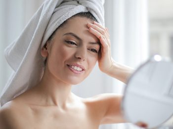 woman looking into mirror