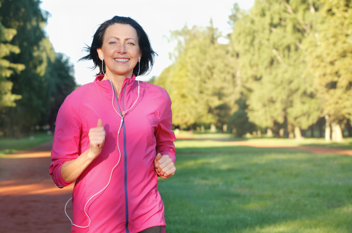 Portrait of elderly woman running with headphones in the park for laser treatments Dr. Irwin answers on SkinTour