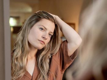 woman looking in mirror