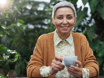 woman smiling holding a cup of tea