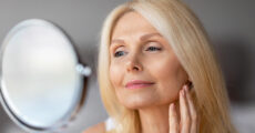 older blonde woman looking into a mirror
